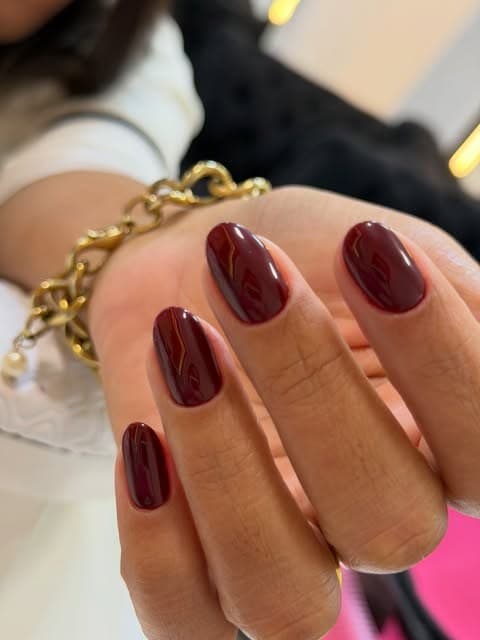 Unhas em vermelho escuro com acabamento espelhado